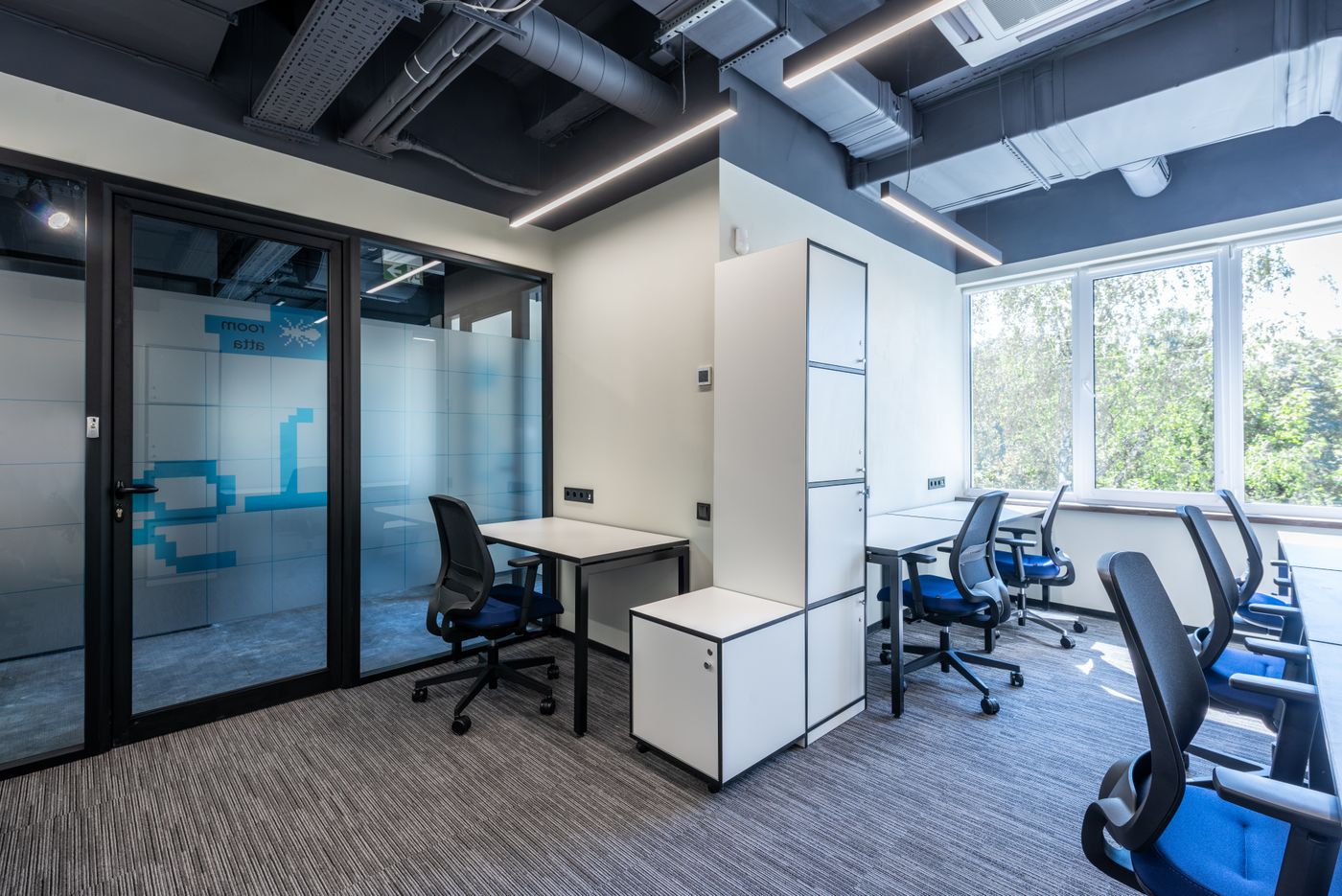 Helles Büro mit modernen Schreibtischen und ergonomischen Bürostühlen – Symbolbild